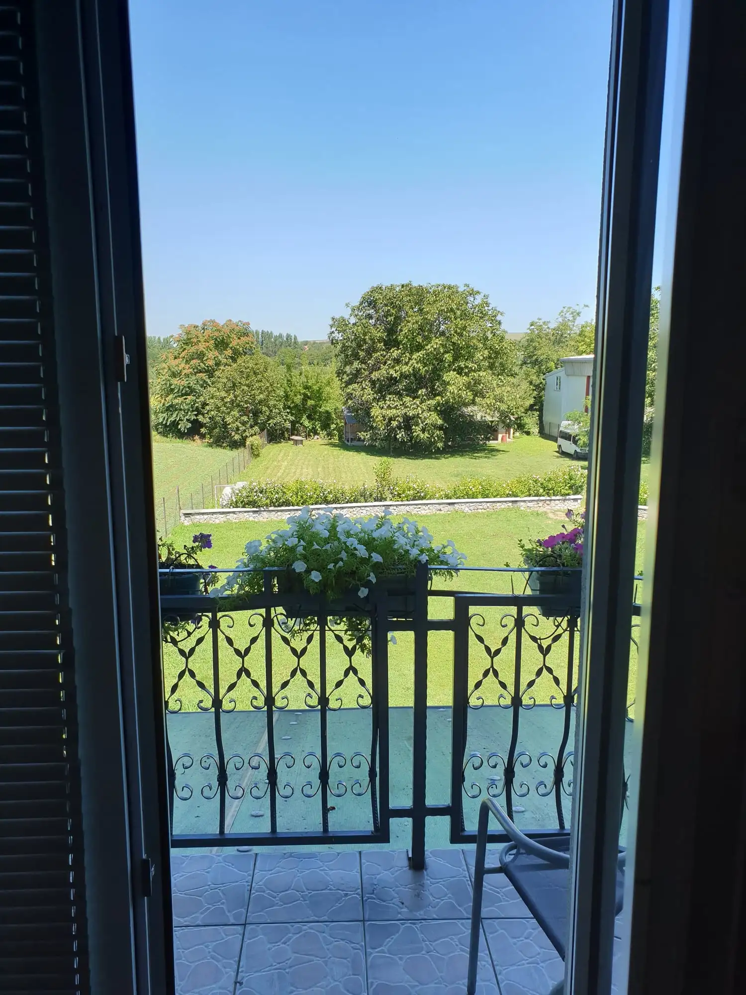 View from a room balcony over the garden and greenery behind the villa