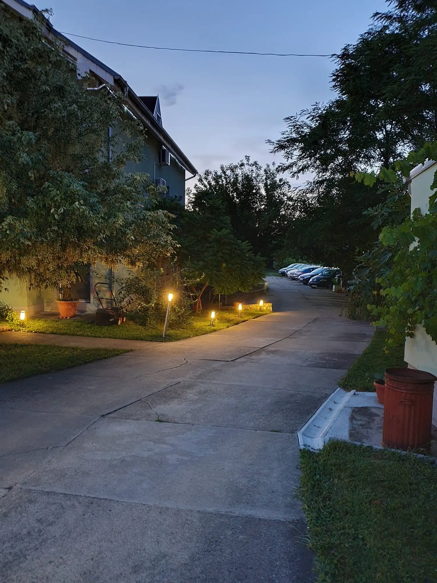 Driveway and parking at the villa with lights on at dusk