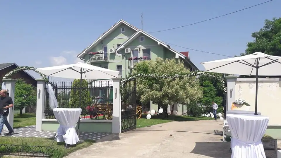 Visoki stolovi i suncobrani postavljeni za proslavu u dvorištu