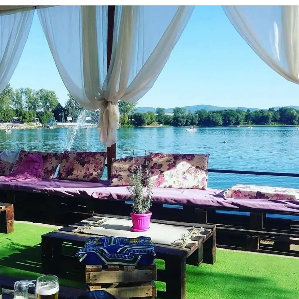 Lounge on the lake shore with cushions and a view of the water